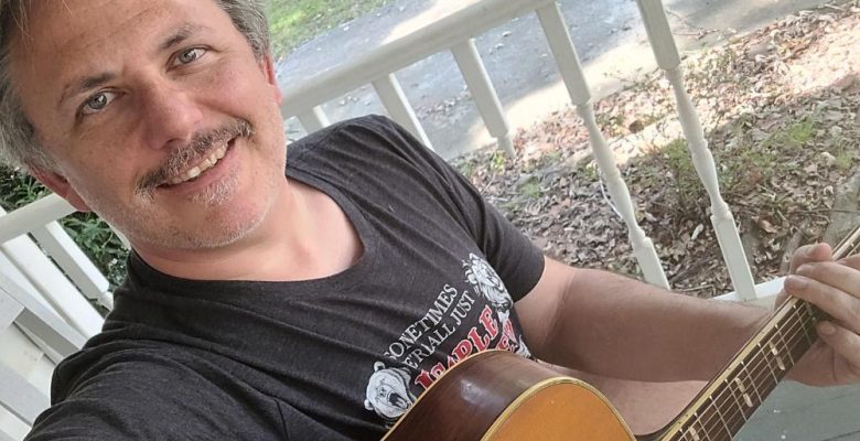 Photo of Assembly Sites owner, Josef, playing guitar